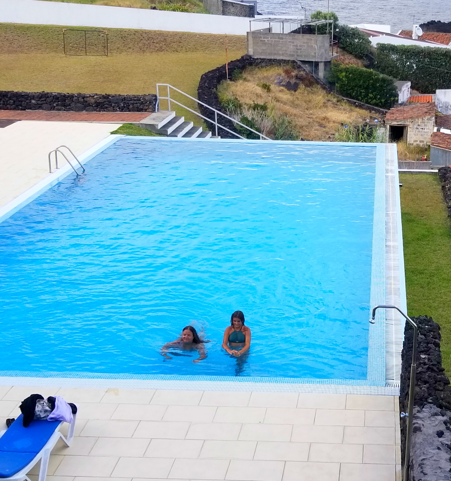 mom and daughter swimming in infinity pool in azores islands